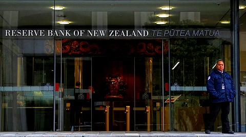 FILE PHOTO: A security guard stands outside the main entrance to the Reserve Bank of New Zealand located in central Wellington, New Zealand, July 3, 2017. 