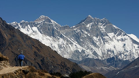 FILE PHOTO: A tourist looks at a view of Mt. Everest from the hills of Syangboche in Nepal December 3, 2009. 