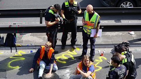 Police surround activists of the "Letzte Generation" (Last Generation) after they glued their hands on asphalt, while blocking the central highway A100 to protest for climate councils, a speed limit on highways as well as for affordable public transport, in Berlin, Germany, May 22, 2023. 