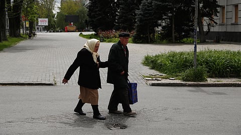 FILE PHOTO: Elderly people walk in the city centre after a 58-hour curfew, amid Russia's attack on Ukraine, in Kherson, Ukraine May 8, 2023. 