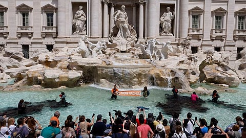 Climate activists pour vegetable charcoal in the Trevi Fountain water, during a demonstration against fossil fuels, in Rome, Italy May 21, 2023 in this image obtained from social media. 