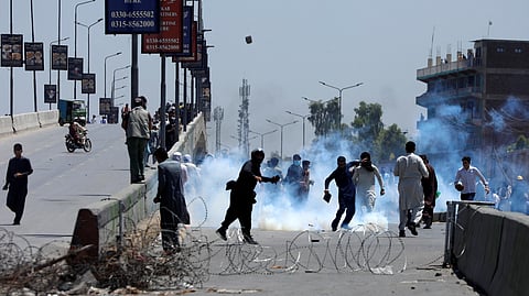Supporters of Pakistan's former Prime Minister Imran Khan throw stones towards police during a protest against Khan's arrest, in Peshawar, Pakistan, May 10, 2023. 