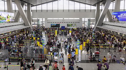 FILE PHOTO: Passengers queue at airline counters in the Ninoy Aquino International Airport, in Pasay City, Metro Manila, Philippines, January 2, 2023. 