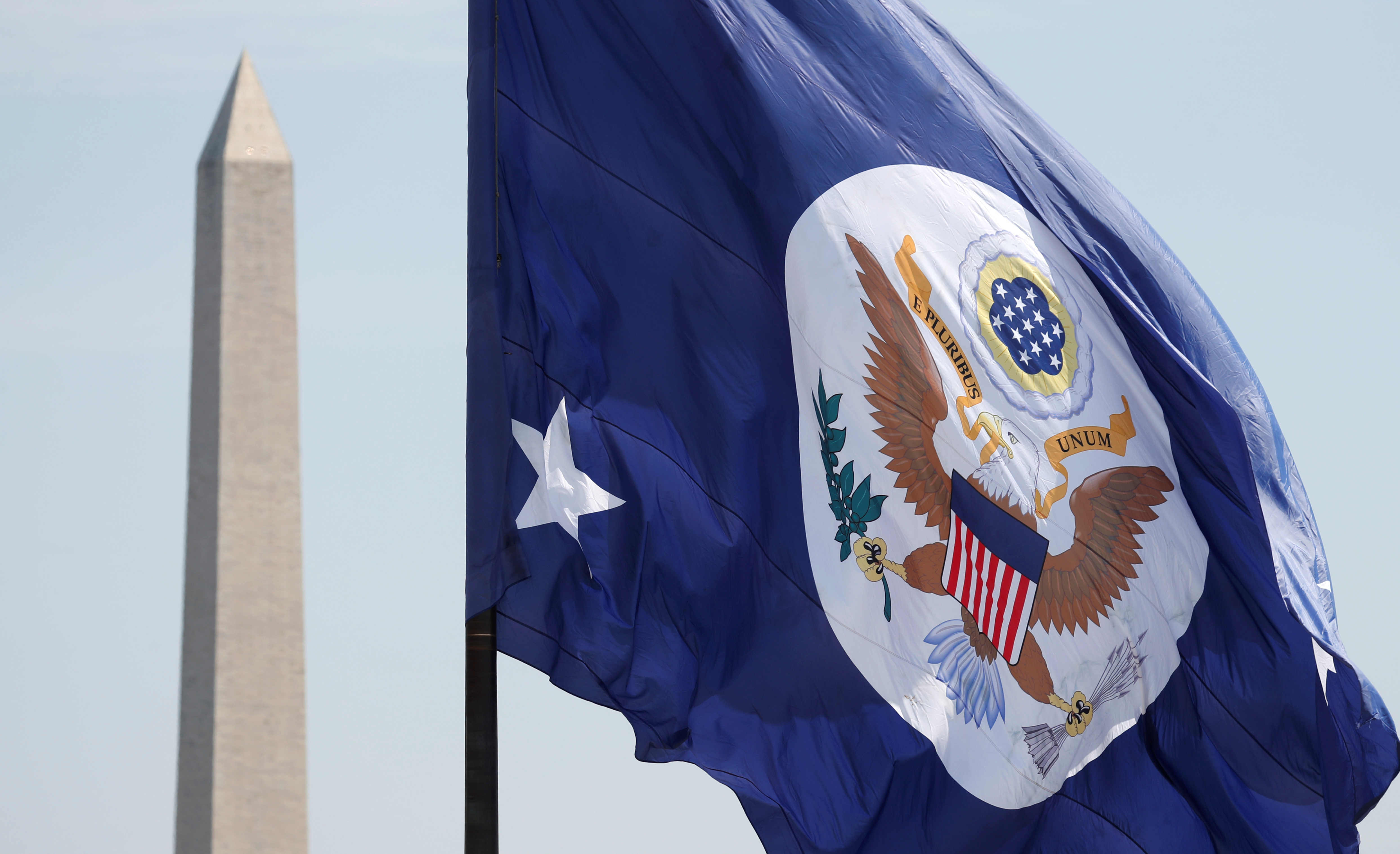 FILE PHOTO: With the Washington Monument behind, the State Department flag flies over its grounds in Washington, U.S., May 8, 2018. 