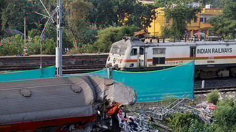 A train moves past a damaged coach, after the tracks were restored, at the site of a train collision following the accident in Balasore district in the eastern state of Odisha, India, June 5, 2023. 