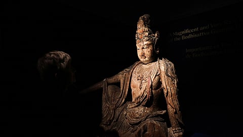FILE PHOTO: Head of Chinese Art Caroline Schulten at Bonhams auction house looks at a rare Buddha statue, believed to be from the 12th century in China, before its auction in Paris, France, June 9, 2023. 