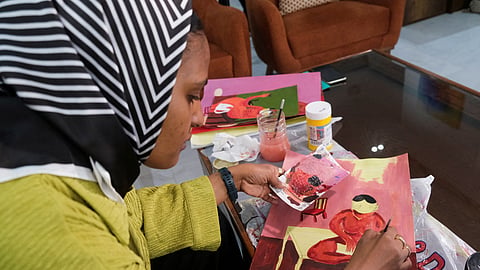 FILE PHOTO: Reem Al Jeally, a Sudanese artist, works on a new painting at her rented house in Cairo, Egypt May 25, 2023. Reem, who with other Sudanese artists fled a raging war back home to Egypt, has left behind more than 50 large canvases at her apartment and gallery in Khartoum as some artists use their brushstrokes to document their memoirs of the war in their own way. 