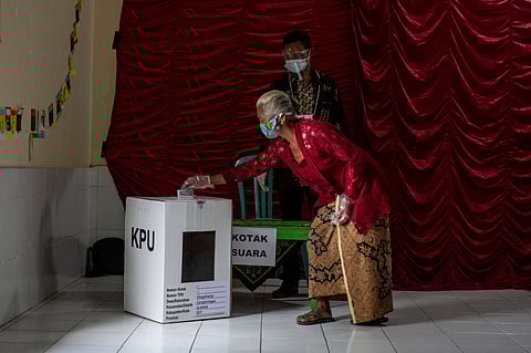 FILE PHOTO: A woman casts her ballot during regional elections amid the COVID-19 pandemic in Sleman, Yogyakarta province, Indonesia December 9, 2020. 