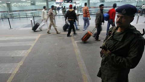 FILE PHOTO: A paramilitary soldier stands guard as passengers arrive at the international airport in New Delhi December 5, 2008. 