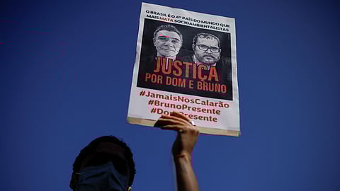 FILE PHOTO: A demonstrator holds a sign during a protest, to demand justice for journalist Dom Phillips and indigenous expert Bruno Pereira, who were murdered in the Amazon, in Brasilia, Brazil June 19, 2022. 