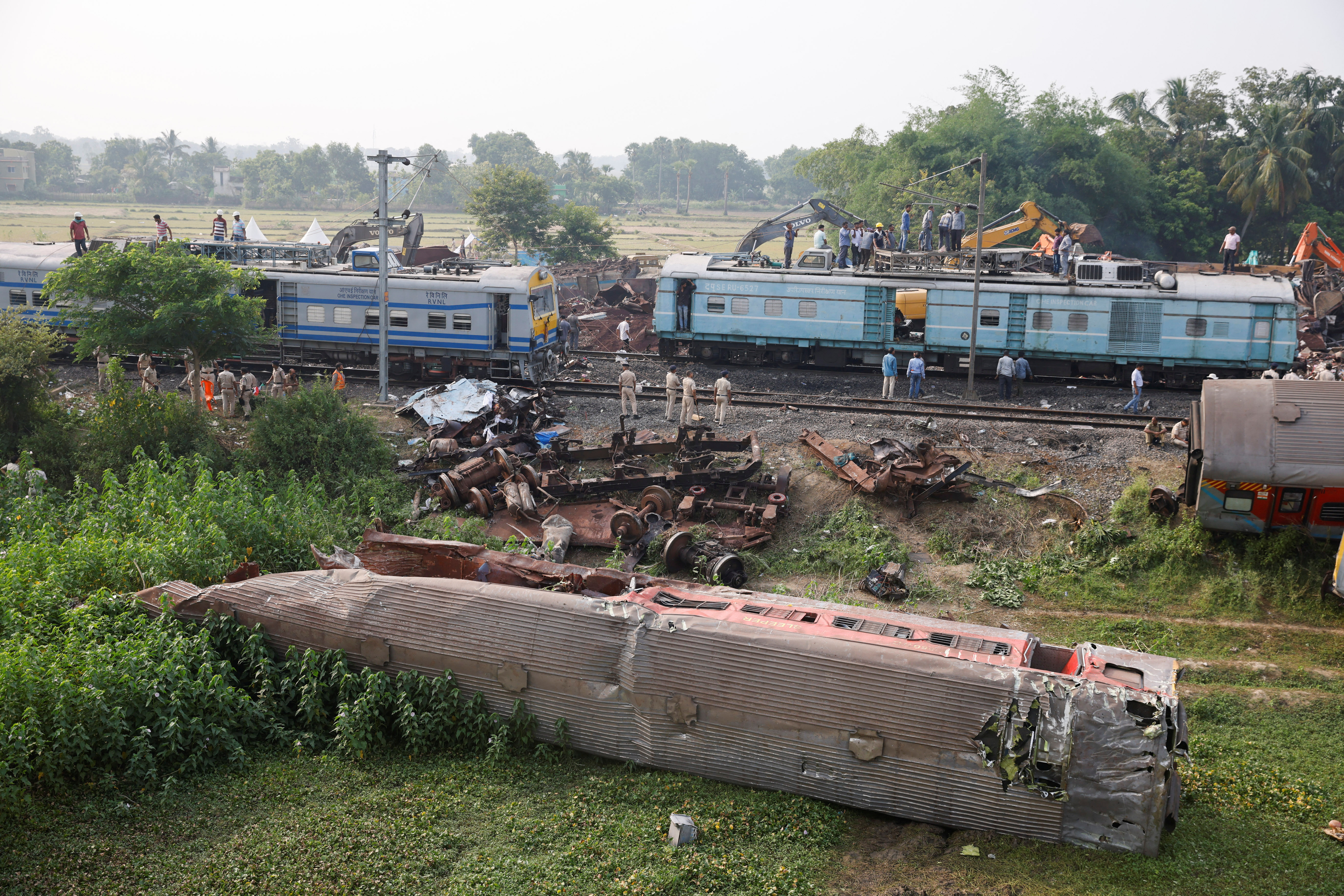Heavy machinery removes damaged coaches from the railway tracks at the site of a train collision following the accident in Balasore district in the eastern state of Odisha, India, June 4, 2023. 