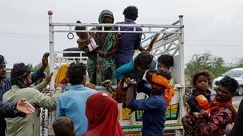 A man carries a child from a truck during an evacuation before the arrival of cyclone Biparjoy in Jakhau in the western state of Gujarat, India, June 14, 2023. 