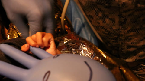 FILE PHOTO: One of the surviving children from a Cessna 206 plane crash in the thick jungle, holds a surgical glove with a happy face drawn on it, while being transferred to Bogota via air in San Jose del Guaviare, Colombia, June 9, 2023. 