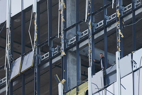 A member of the security services investigates the damaged building following a reported drone attack in Moscow, Russia, July 24, 2023. 
