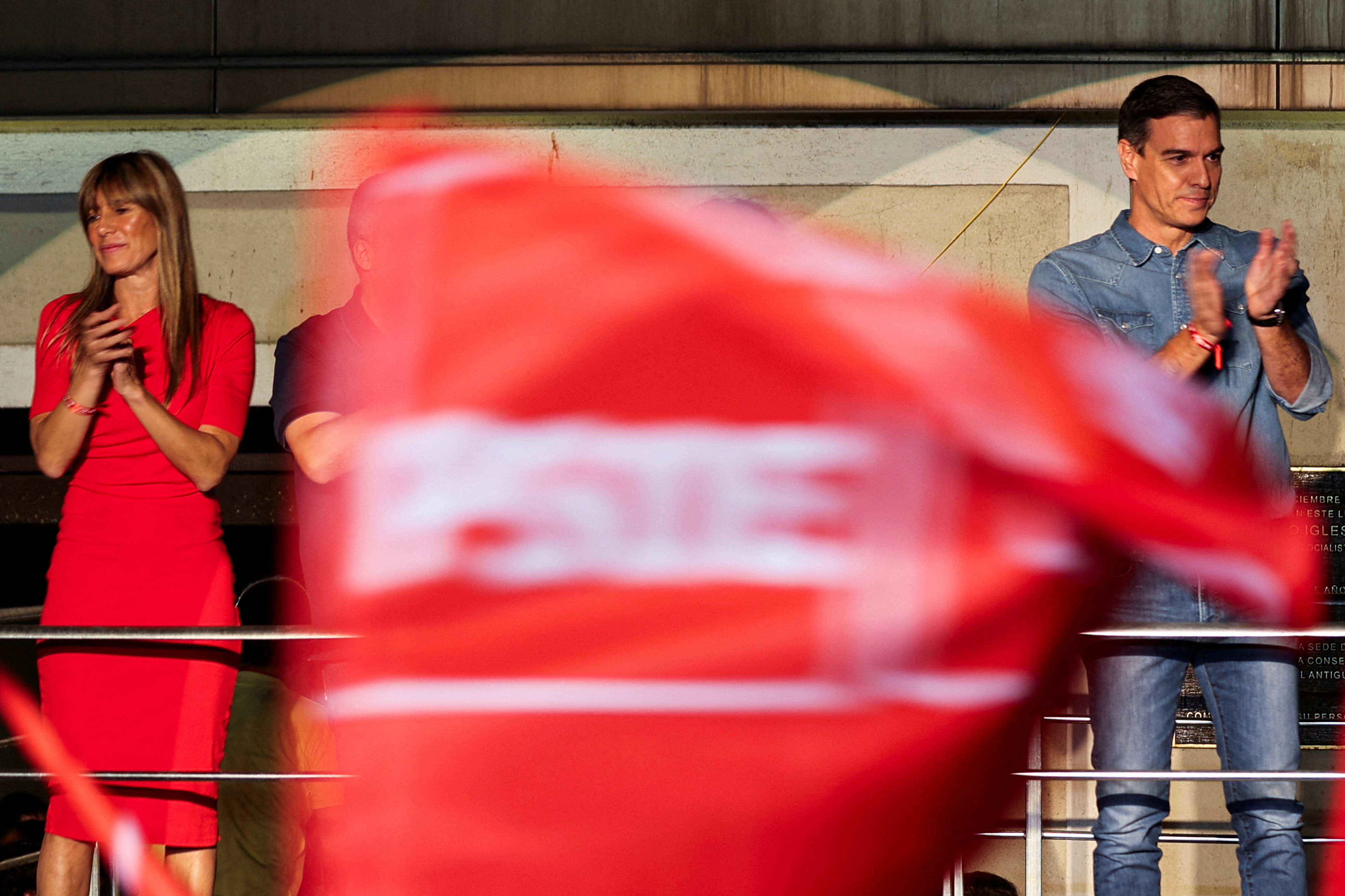 Spain's Socialist leader and Prime Minister Pedro Sanchez, accompanied by his wife Begona Gomez, applauds as he addresses supporters during the general election, in Madrid, Spain, July 23, 2023. 