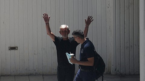 FILE PHOTO: British pensioner David Hunter waves to journalists while being escorted to a police van outside a courthouse in Paphos, Cyprus July 21, 2023. 