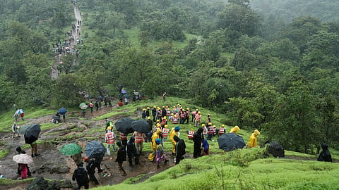 National Disaster Response Force (NDRF) personnel and other volunteers climb up a mountain to reach the site of a landslide at a village in Raigad, in the western state of Maharashtra, India July 20, 2023. 