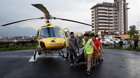 FILE PHOTO: People carry the body of a person killed in a helicopter crash belonging to Manang air, at Tribhuvan University Teaching Hospital in Kathmandu, Nepal July 11, 2023. 