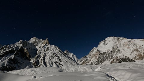 FILE PHOTO: The world's second largest mountain, the 8,611 meter high K2 (seen in the distance), and the 8,051 meter high Broad Peak (R), are illuminated by the moon at Concordia, the confluence of the Baltoro and Godwin-Austen glaciers, in the Karakoram mountain range in Pakistan September 7, 2014. 