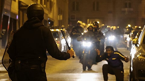 A person reacts while a police officer holds a baton during protests following the death of Nahel, a 17-year-old teenager killed by a French police officer in Nanterre during a traffic stop, in Paris, France, July 2, 2023. 