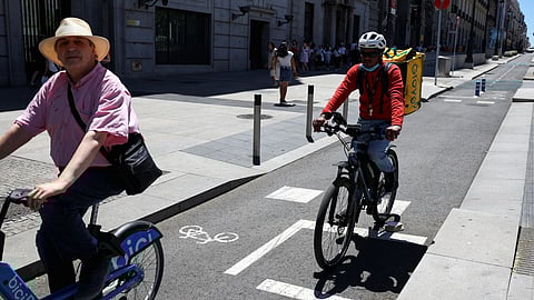 FILE PHOTO: People ride bicycles on a bike lane in downtown Madrid, in Spain, July 15, 2023. 