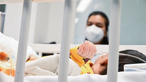FILE PHOTO: A mother watches her child who is suffering from an RS Virus infection at the paediatric intensive care unit at the Asklepios Clinic in Sankt Augustin, Germany, December, 6, 2022. 