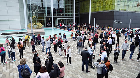 People gather outside a building after a strong earthquake shook Colombian capital Bogota, prompting evacuations of offices and restaurants, in Bogota, Colombia, August 17, 2023. 