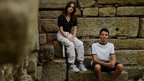 Andre, 15 and Sofia Oliveira, 18 pose for a picture in Almada, Portugal, July 29, 2023. 
