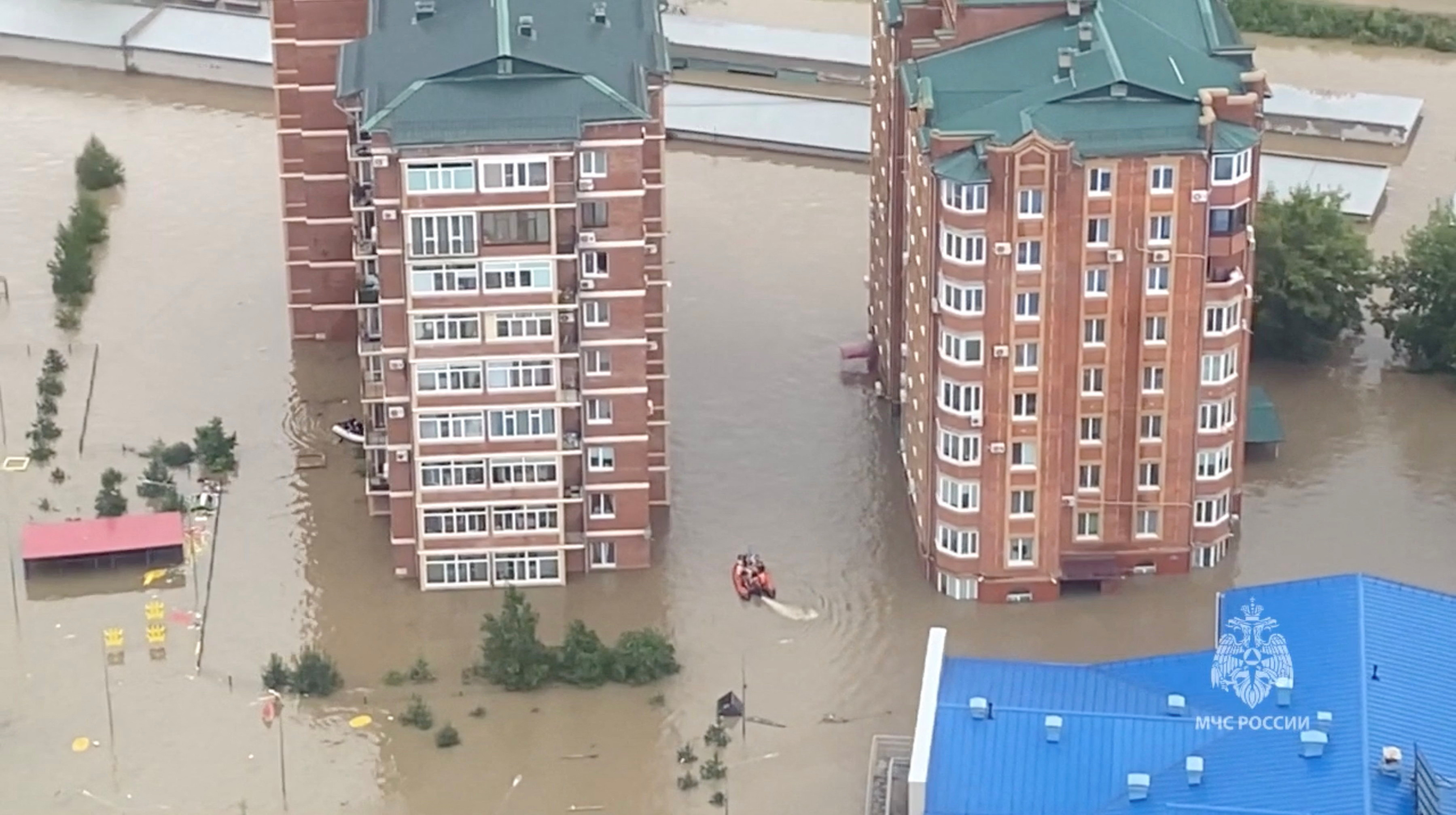 Rescuers use inflatable boats to evacuate residents of the area flooded due to a dam break in Ussuriysk, Russia, in this still image taken from video released August 12, 2023. 