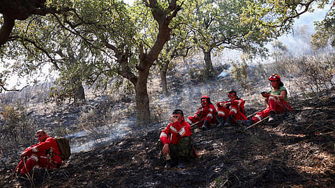 Military members of emergency services rest as they try to contain a wildfire near Qeparo, Albania, August 19, 2023. 