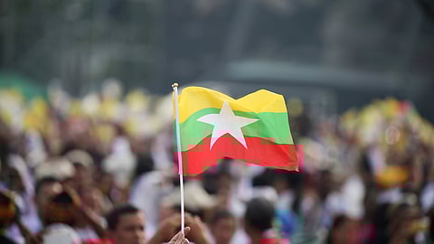 FILE PHOTO: A Catholic faithful waves a Myanmar flag as Pope Francis arrives to lead a mass at Kyite Ka San Football Stadium in Yangon, Myanmar November 29, 2017. 
