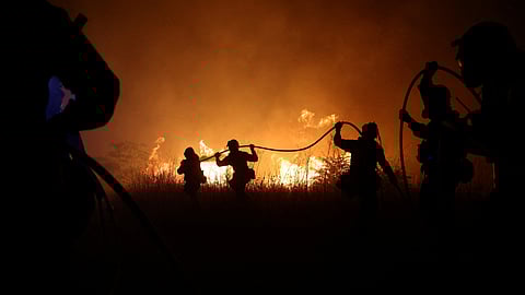 Firefighters try to extinguish a wildfire burning near the village of Makri on the region of Evros, Greece, August 22, 2023. 