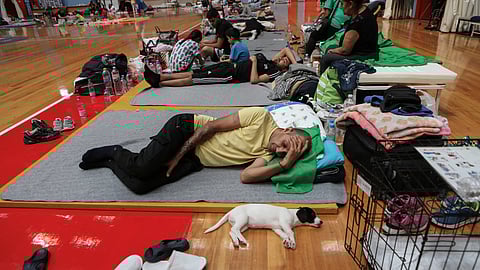A man and his dog find shelter in an indoor stadium after being evacuated from flooded areas, in the aftermath of Storm Daniel, in Larissa, Greece, September 10, 2023. 