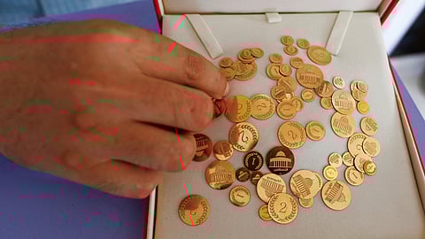 FILE PHOTO-Palestinian businessman Ahmed Hamdan offers gold coins to low-income residents seeking savings, in Gaza City August 27, 2023. 