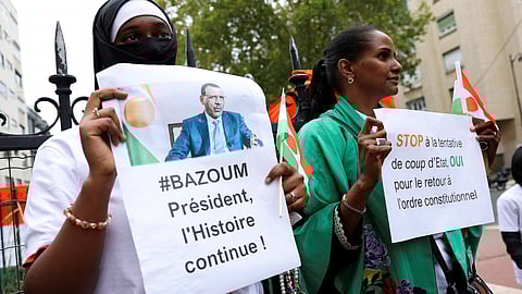  Demonstrators hold placards and Niger's flags as they gather outside Niger's embassy in support of the President of Niger Mohamed Bazoum in Paris, France, August 5, 2023. 