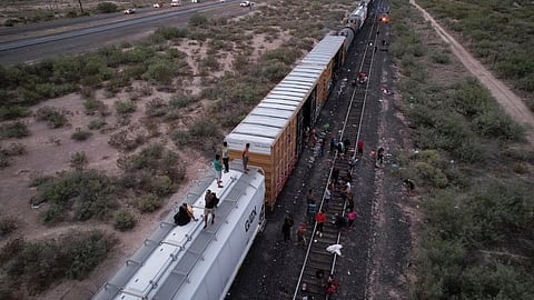 Migrants travelling by train to Ciudad Juarez in an attempt to reach the United States, wait near train wagons while being stranded near Villa Ahumada, in the state of Chihuahua, Mexico September 29, 2023. 
