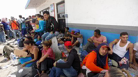 Asylum seekers rest for a moment before continuing to walk along the highway from Nava to Piedras Negras, Coahuila state, as they continue their journey to reach the U.S. border, in Nava, Mexico September 26, 2023. 