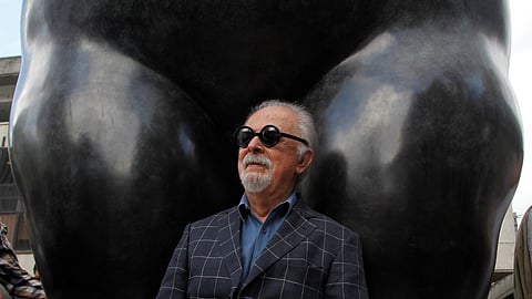 Colombian painter and sculptor Fernando Botero sits underneath one of his sculptures during a stroll with Medellin's Mayor Federico Gutierrez (not pictured) in Medellin, Colombia January 27, 2017. 