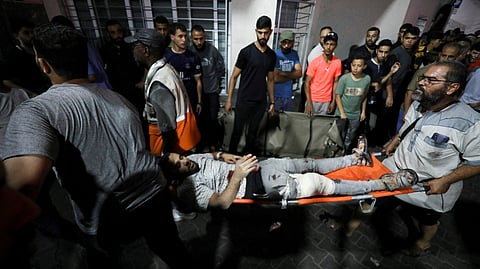An injured person is assisted at Shifa Hospital after hundreds of Palestinians were killed in a blast at Al-Ahli hospital in Gaza that Israeli and Palestinian officials blamed on each other in Gaza City, Gaza Strip, October 17, 2023. 