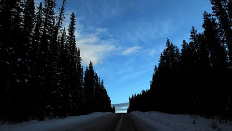 FILE PHOTO: A snow covered road leads up a hill at dusk in Banff National Park near Lake Louise, Alberta December 2, 2011. 