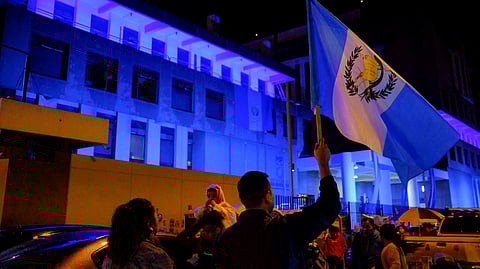 FILE PHOTO: A demonstrator holds up a Guatemalan national flag during a blockade of the Public Ministry building to demand the resignation of powerful senior prosecutors accused of working to undermine President-elect Bernardo Arevalo's ability to take office, in Guatemala City, Guatemala October 6, 2023. 