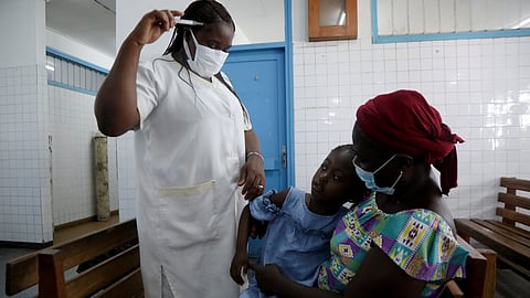 A nurse prepares to take the temperature of a child with malaria at Marcory General Hospital in Abidjan, Ivory Coast October 7, 2021. 