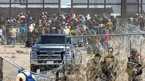 Migrants gather near the border fence after they forced their way by breaking through razor wire and a fence, as SB 4 law that would empower law enforcement authorities in the state to arrest people suspected of illegally crossing the U.S.-Mexico border was temporarily blocked, as seen from Ciudad Juarez, Mexico, March 21, 2024.

