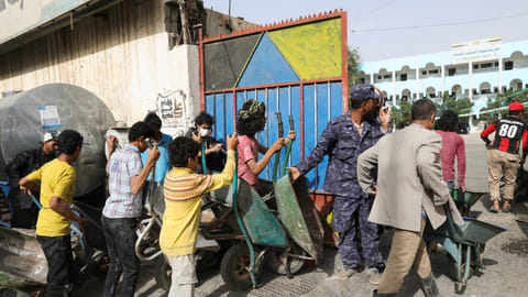FILE PHOTO: Workers wait to ferry foodstuff outside an aid distribution center in Sanaa, Yemen September 28, 2022. 