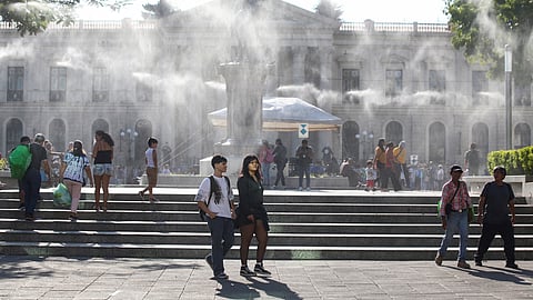 People walk as water is sprayed by a system to alleviate the high temperatures caused by a heat wave, at the Gerardo Barrios square, in San Salvador, El Salvador, March 27, 2024. 