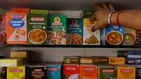 FILE PHOTO: A man adjusts the spice boxes of MDH and Everest on the shelf of a shop at a market in New Delhi, India, April 29, 2024. 