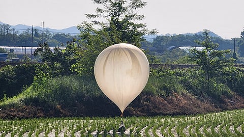 FILE PHOTO: A balloon believed to have been sent by North Korea, carrying various objects including what appeared to be trash and excrement, is seen over a rice field at Cheorwon, South Korea, May 29, 2024. 
