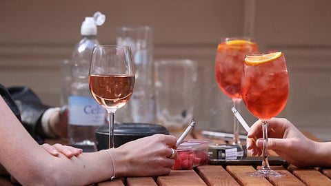 Women smoke outside a pub in Covent Garden, London, Britain, August 29, 2024. 
