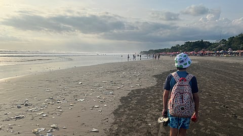 A boy walks on a beach polluted by plastic trash in Bali, Indonesia, April 17, 2023. 