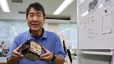 FILE PHOTO: Takao Doi, a former Japanese astronaut and professor at Kyoto University, holds an engineering model of LignoSat during an interview with Reuters at his laboratory at Kyoto University in Kyoto, Japan, October 25, 2024. 